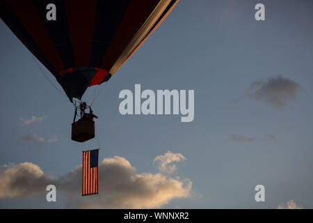 Reno, Nevada, USA. 6th Sep, 2019. A balloon carrying the American flag flies over Rancho San Rafael Regional Park in Reno, Nevada, Friday morning as the National Anthem plays during the official start of the 38th Great Reno Balloon Race. The race, the world's largest free hot-air ballooning event, runs September 6-8, 2019. Credit: Tracy Barbutes/ZUMA Wire/Alamy Live News Stock Photo