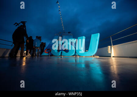 06 September 2019, Bavaria, Weßling: Two men pass a CSU logo on the deck during the cruise on Lake Starnberg as part of the CSU board meeting. Photo: Lino Mirgeler/dpa Stock Photo