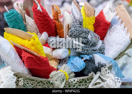 Rolls with lace in different colors in the basket. Stock Photo