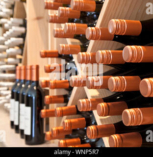 Bottles of wine for sale on racks in winery shop tasting room, Nelson, New Zealand. Selective focus on foreground. Stock Photo