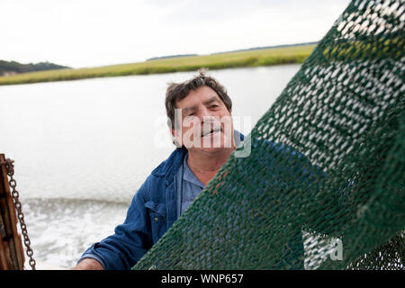 Happy commercial fisherman working on the deck of a boat. Stock Photo