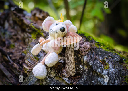 A beautiful picture with a birch mushroom in the forest, with a toy white cute mouse-the symbol of 2020 Stock Photo