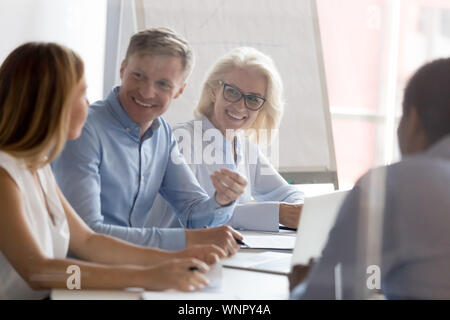 Smiling diverse employees brainstorm sharing ideas at workplace Stock ...