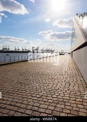 Harbour area in the Hamburg along the river with cranes and buildings Stock Photo