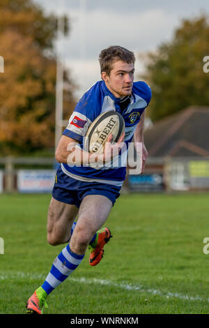 Amateur rugby union player running with ball held close in control Stock Photo