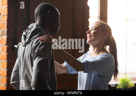 Smiling woman greeting African American man at sudden meeting Stock Photo