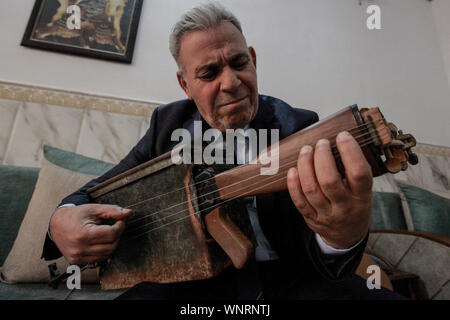 Baghdad, Iraq. 06th Sep, 2019. Iraqi teacher and musician Majed Abdennour plays a musical instrument made from a Kalashnikov assault rifle and an ammunition box. Abdennour had the Kalashnikov at home between 2006 and 2008 to protect his family during the sectarian violence between the militias and extremists of the Iraqi Sunnis and Shiites factions. After more than 10 years of abandoning his weapon, Abdennour decided to bring it to a metalworker to transform it into a musical instrument that performs as a lute. Credit: Ameer Al Mohammedaw/dpa/Alamy Live News Stock Photo