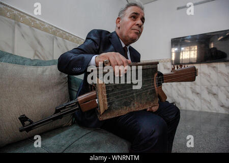 Baghdad, Iraq. 06th Sep, 2019. Iraqi teacher and musician Majed Abdennour plays a musical instrument made from a Kalashnikov assault rifle and an ammunition box. Abdennour had the Kalashnikov at home between 2006 and 2008 to protect his family during the sectarian violence between the militias and extremists of the Iraqi Sunnis and Shiites factions. After more than 10 years of abandoning his weapon, Abdennour decided to bring it to a metalworker to transform it into a musical instrument that performs as a lute. Credit: Ameer Al Mohammedaw/dpa/Alamy Live News Stock Photo