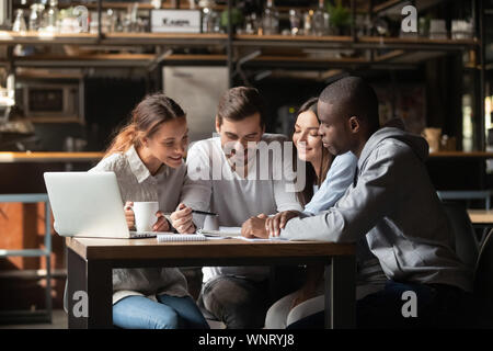 Happy diverse people working with paper documents in cafe together Stock Photo