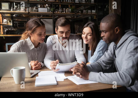 Diverse friends, students doing paperwork in cafe together Stock Photo