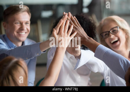 Excited diverse employees give high five motivated for success Stock Photo