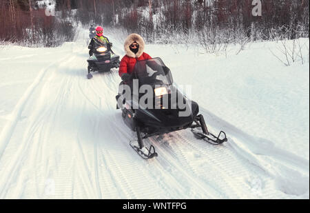 A snowmobile (snow machine, motor sled, motor sledge, skimobile,  snowscooter, sled or Ski-Doo) sits atop snow with trees in the background  in Japan Stock Photo - Alamy