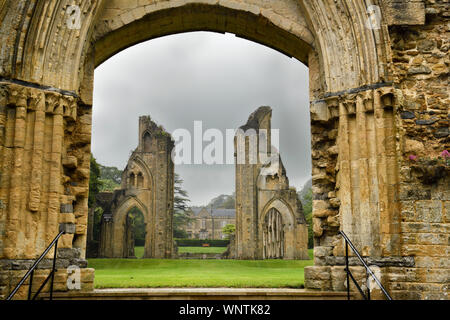 View of Abbey House and ruins of the Great Church from Lady Chapel at Glastonbury Abbey monastery in pouring rain in Glastonbury England Stock Photo