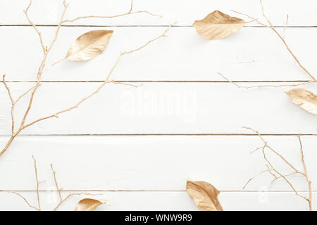 Autumn composition. Frame made of fall leaves and golden decorations on wooden white background. Flat lay, top view, overhead. Nordic, hygge, cozy hom Stock Photo
