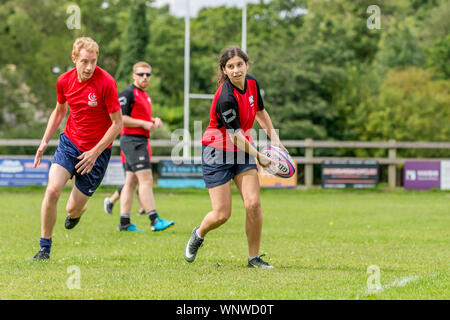Amateur touch rugby player (female, 14-20 y) prepares to pass the ball to teammate Stock Photo