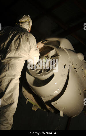 Tradesman sprays the primer coat on the engine on a Dornier 228 aircraft Stock Photo