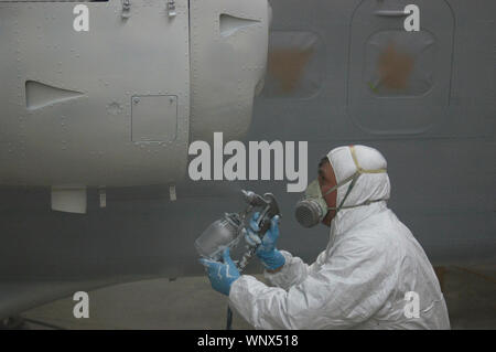 Tradesman sprays the engine on a Dornier 228 aircraft Stock Photo