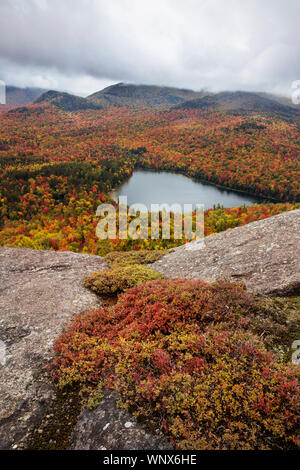 Colorful overlooks views of endless forest in full fall colors with ponds throughout the states of New York, New Hampshire, Vermont, New England. Stock Photo