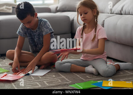 Diligent children preparing notebooks for new school year Stock Photo