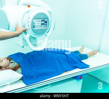 Medicine concept ,Technician Doctor male radiologist with colleague setting up machine to take female patient in x-ray room Stock Photo