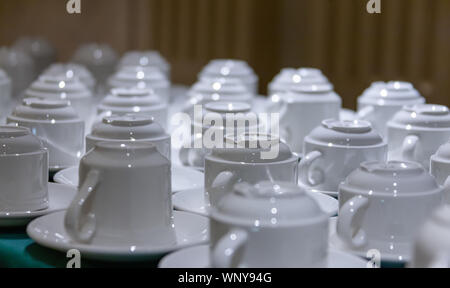 A lot of coffee cups on a table with blue tablecloth simplistic Stock Photo