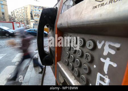 Bucharest, Romania - November 15, 2018: An out of use old public telephone with buttons in an advanced state of degradation is mounted on wall in down Stock Photo