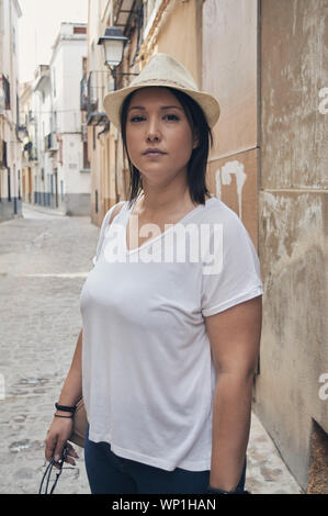 portrait of tourist girl looking at camera while walking through old town area