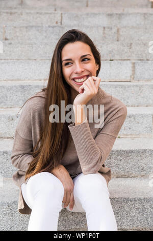 Portrait of a smiling woman resting her head on her hand Stock Photo