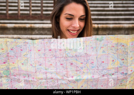 smiling young girl looking at a map Stock Photo