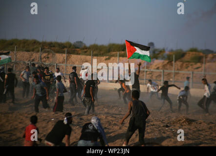 Gaza, Palestine. 06th Sep, 2019. Demonstrators flee from tear gas canisters fired towards them during an anti-Israel demonstration at the Israel-Gaza border fence in the southern Gaza Strip. Credit: SOPA Images Limited/Alamy Live News