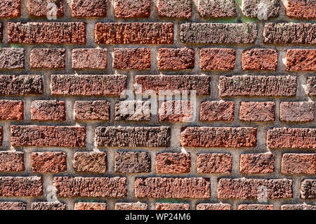 A red brick wall in sunlight with dark colored mortar Stock Photo