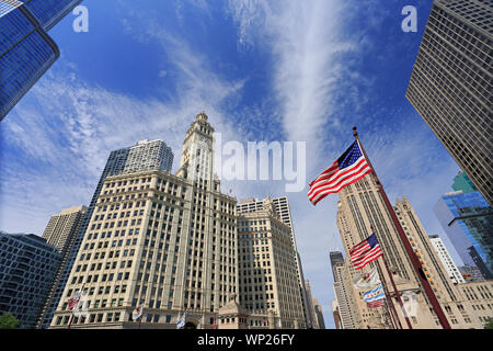 Wrigley Building and Tribune Tower on Michigan Avenue with Illinois flag on the foreground in Chicago, USA