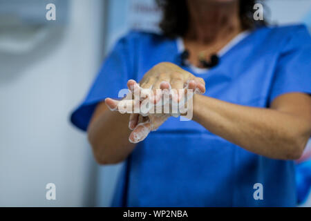 Details with a medic washing her hands before a medical procedure