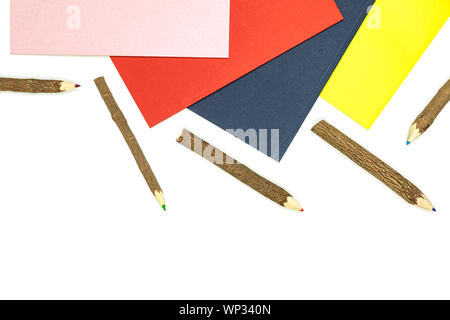 Colored pencils made from branches of trees and colored books isolate on white background. Stock Photo