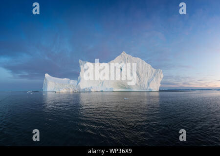 Icebergs in front of the fishing town Ilulissat in Greenland. Nature and landscapes of Greenland. Travel on the vessel among ices. Seascape