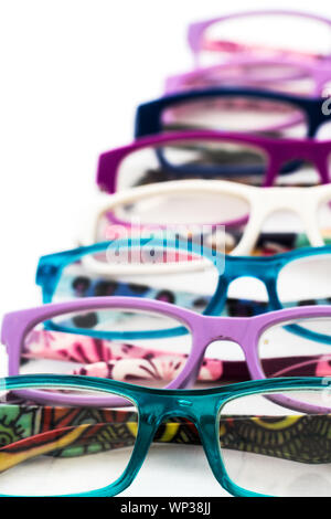 vibrant sunglasses in multiple colors lined on a wooden summer deck railing fashion and uv eye protection concept Stock Photo