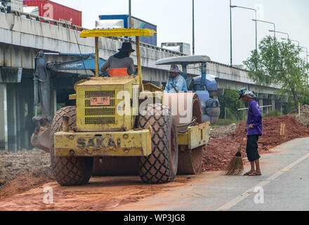 SAMUT PRAKAN, THAILAND, APR 27 2019, Road roller working at road construction. Vibratory soil compactor working on highway construction site. Stock Photo