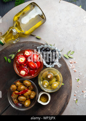 Italian food ingredients Black and green olives in glass bowls and olive oil, stuffed with cheese small bell peppers and red cranberries, herbs. Top Stock Photo