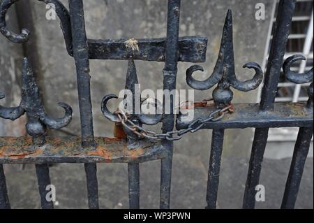 A rusting padlock and chain on a gate and railings in TRalee, CO Kerry Stock Photo