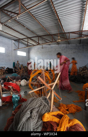 Women spinning the wool in spinning wheel Stock Photo