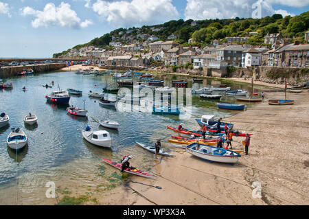 Sea Kayakers on beach in Mousehole Harbour. Cornwall, England, UK Stock Photo