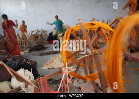 Woman spinning the wool in spinning wheel Stock Photo