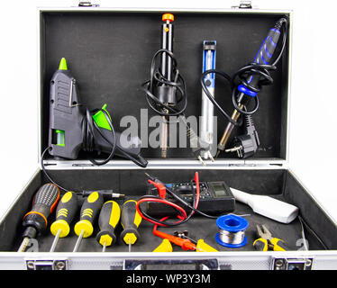 Aluminum case with a working tool on a white background - screwdrivers, pliers, soldering irons. Stock Photo