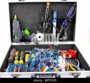 Aluminum case with a working tool on a white background - screwdrivers, pliers, soldering irons. Stock Photo