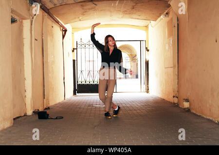 Beauty girl dancing in the arch of the house against sunlight Stock Photo