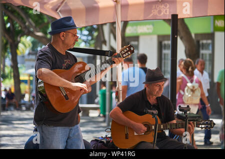 Two musicians playing guitars in the street in Funchal, Madeira. Stock Photo