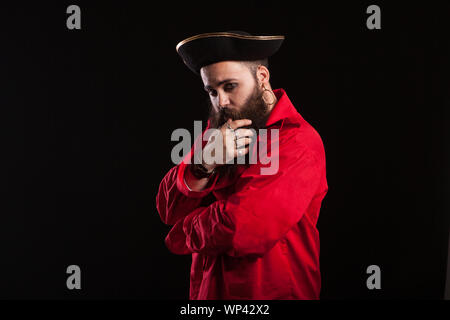 Side view portrait of handsome young man in a pirate costume for halloween carnival. Man in vintage sailor costume. Stock Photo