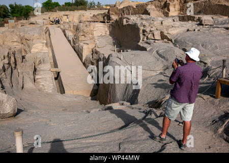 A tourist takes a photograph of the Unfinished Obelisk at the ancient Western Quarry near Aswan in Egypt. Stock Photo