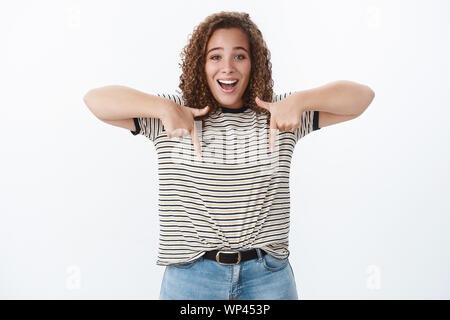 Happiness, diversity body-positivity concept. Gorgeous chubby smiling happy woman lively grinning pointing down index fingers showing awesome advertis Stock Photo