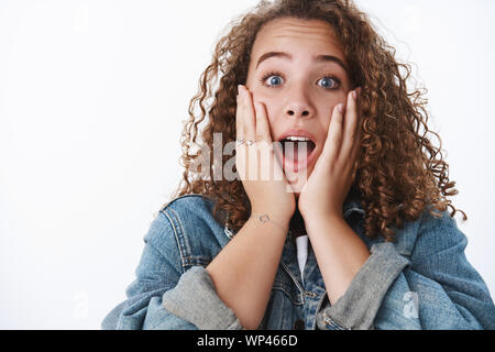 Portrait of astonished anxious girl touch hand head open mouth isolated ...